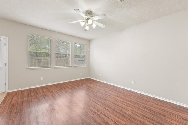 empty room featuring a textured ceiling, ceiling fan, and wood-type flooring