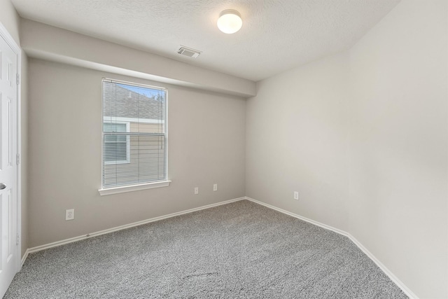 carpeted empty room with a textured ceiling