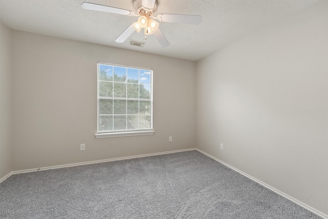 empty room with ceiling fan, carpet, and a textured ceiling