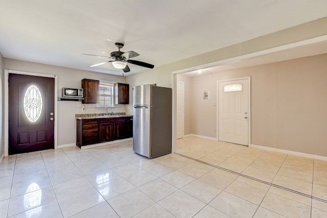 tiled foyer with ceiling fan and sink