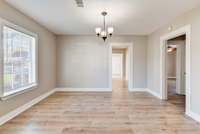 unfurnished room featuring ceiling fan with notable chandelier and light hardwood / wood-style flooring