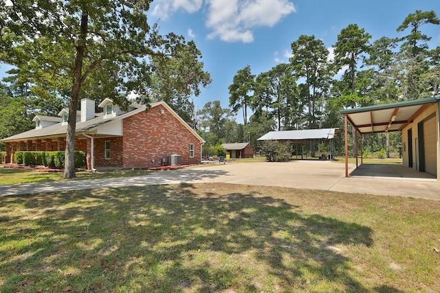 view of yard with central AC and a carport