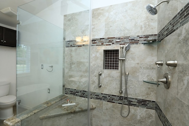 bathroom featuring toilet and a tile shower