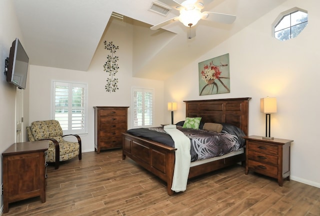 bedroom featuring ceiling fan, vaulted ceiling, dark hardwood / wood-style flooring, and multiple windows