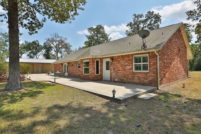 back of house with a lawn and a patio area