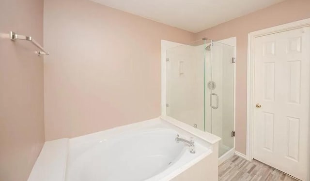 bathroom featuring hardwood / wood-style flooring and separate shower and tub