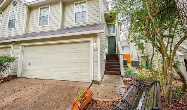 view of front of home with a garage and central air condition unit