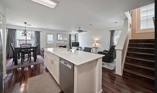 kitchen featuring pendant lighting, stainless steel dishwasher, sink, a kitchen island with sink, and white cabinets