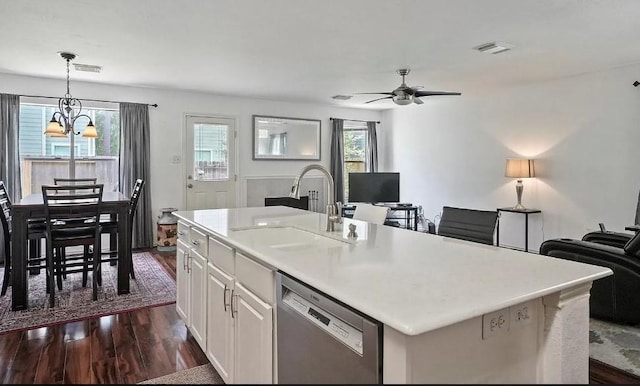 kitchen with stainless steel dishwasher, sink, white cabinetry, hanging light fixtures, and a kitchen island with sink