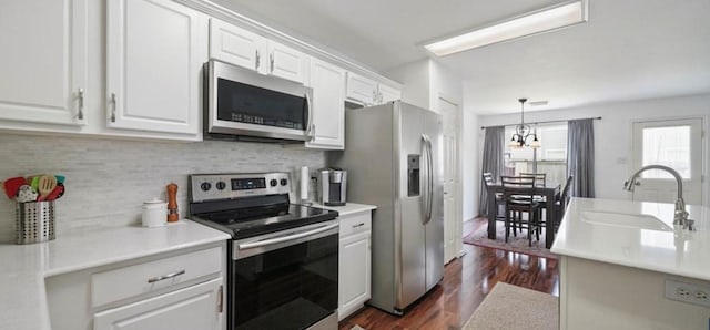 kitchen with decorative light fixtures, sink, white cabinets, and stainless steel appliances