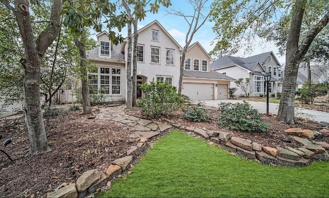 view of property featuring a garage and a front lawn