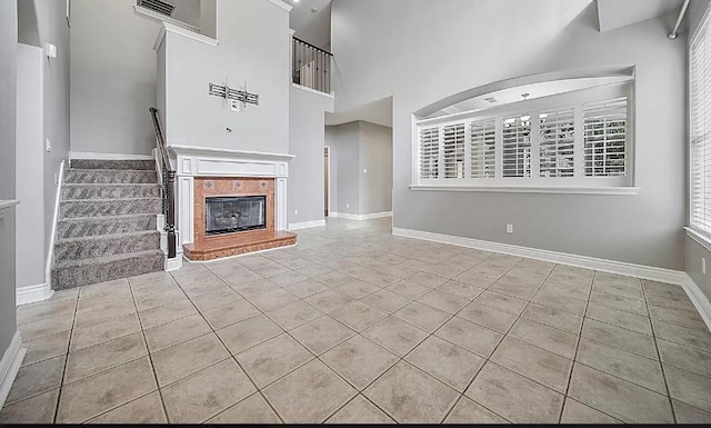 unfurnished living room with light tile patterned floors and a towering ceiling