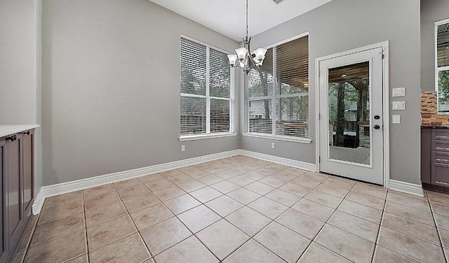 unfurnished dining area with light tile patterned floors and a chandelier