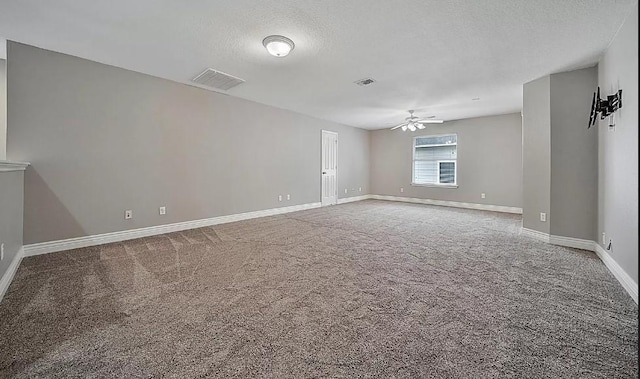 carpeted spare room featuring ceiling fan and a textured ceiling