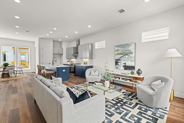 living room featuring sink and light hardwood / wood-style flooring