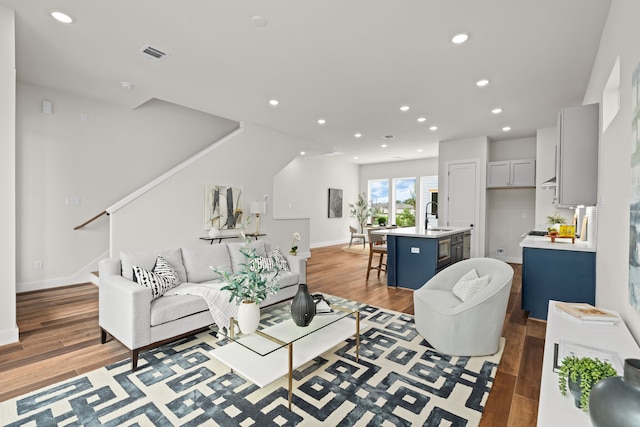 living room featuring hardwood / wood-style flooring and sink