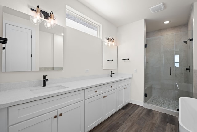 bathroom featuring wood-type flooring, vanity, and plus walk in shower