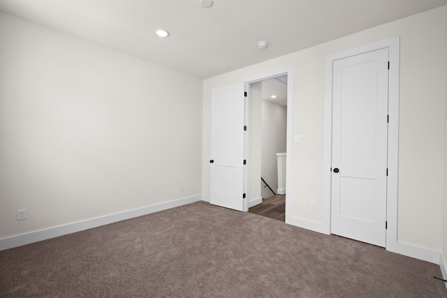 unfurnished bedroom with dark colored carpet