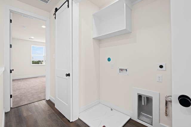 laundry room with a barn door, dark hardwood / wood-style floors, hookup for a washing machine, and hookup for an electric dryer