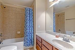 full bathroom featuring toilet, shower / bath combination with curtain, and vanity