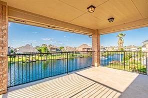 view of patio / terrace featuring a water view and a balcony