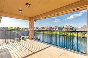 view of patio / terrace with a water view and a balcony