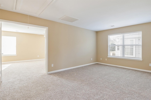 spare room with light colored carpet and a wealth of natural light