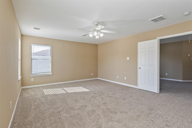 empty room featuring ceiling fan and carpet