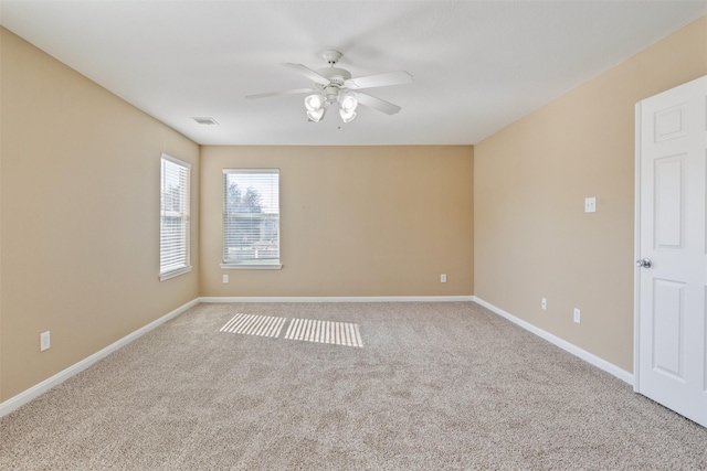 empty room featuring ceiling fan and light colored carpet