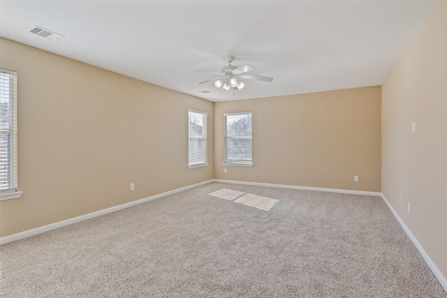 spare room with ceiling fan and carpet