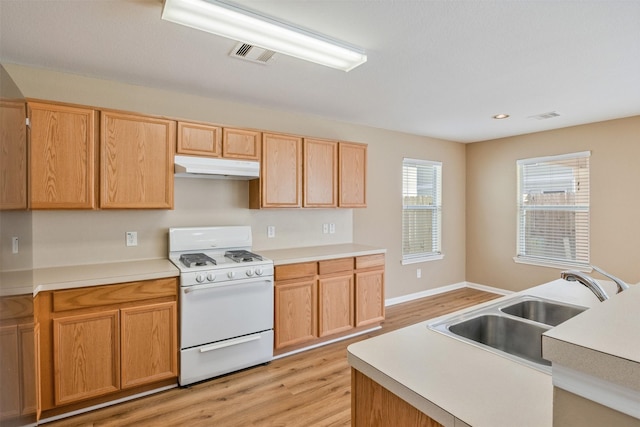 kitchen featuring light wood-type flooring, sink, light brown cabinetry, and white range with gas cooktop