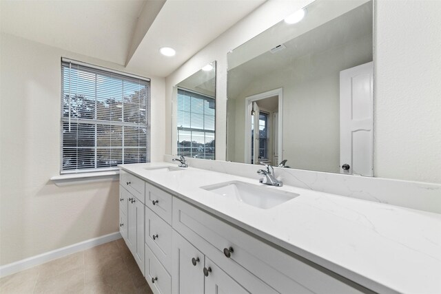 bathroom featuring vanity, tile patterned floors, and lofted ceiling