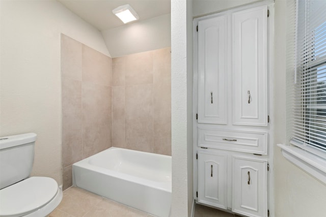 bathroom with lofted ceiling, tub / shower combination, tile patterned floors, and toilet