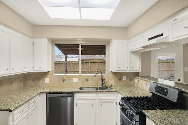 kitchen with white cabinetry, stainless steel range with gas cooktop, black dishwasher, decorative backsplash, and sink