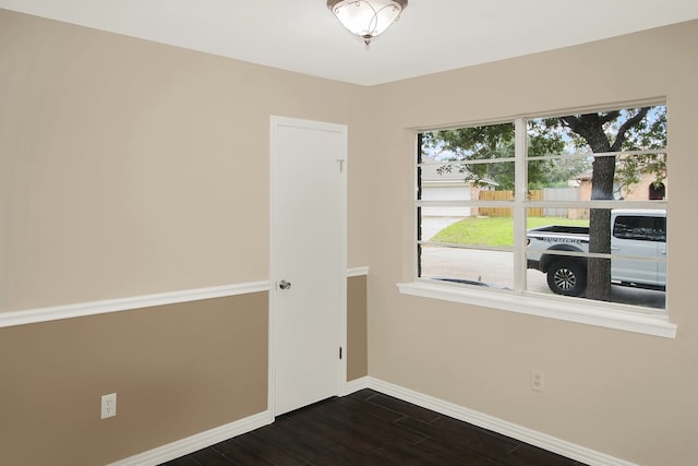 unfurnished room with dark wood-type flooring