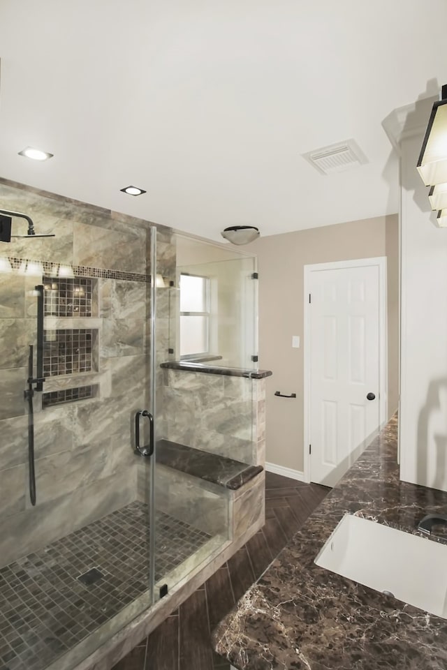 bathroom with a shower with door and sink