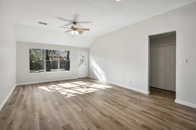 spare room with ceiling fan, vaulted ceiling, and hardwood / wood-style floors