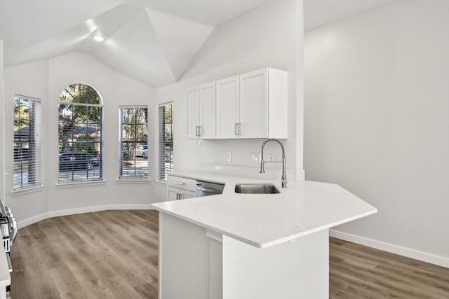 kitchen featuring dishwasher, kitchen peninsula, sink, white cabinetry, and light wood-type flooring