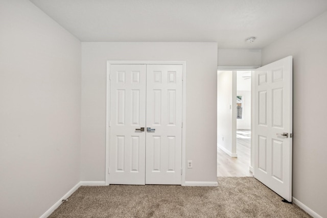 unfurnished bedroom with light carpet and a closet