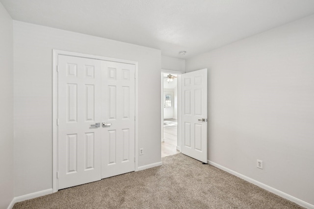 unfurnished bedroom featuring light colored carpet and a closet