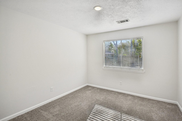 carpeted spare room featuring a textured ceiling