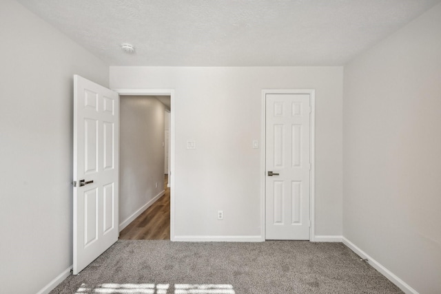 unfurnished bedroom with dark carpet