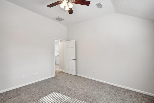 carpeted empty room with lofted ceiling and ceiling fan