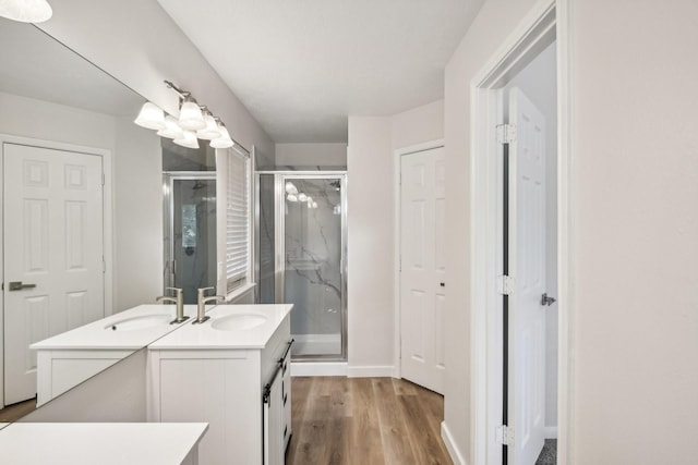 bathroom featuring hardwood / wood-style flooring, a shower with door, and vanity