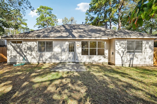 rear view of house featuring a patio area and a lawn