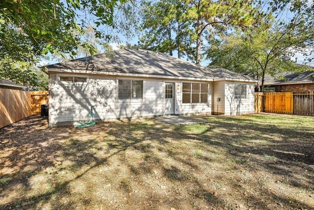 rear view of property with a lawn