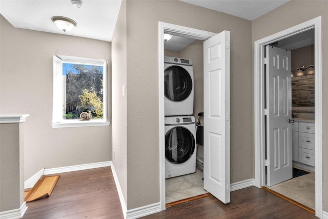 laundry area with dark wood-type flooring and stacked washing maching and dryer