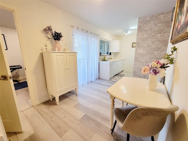 dining space featuring light wood-type flooring and sink