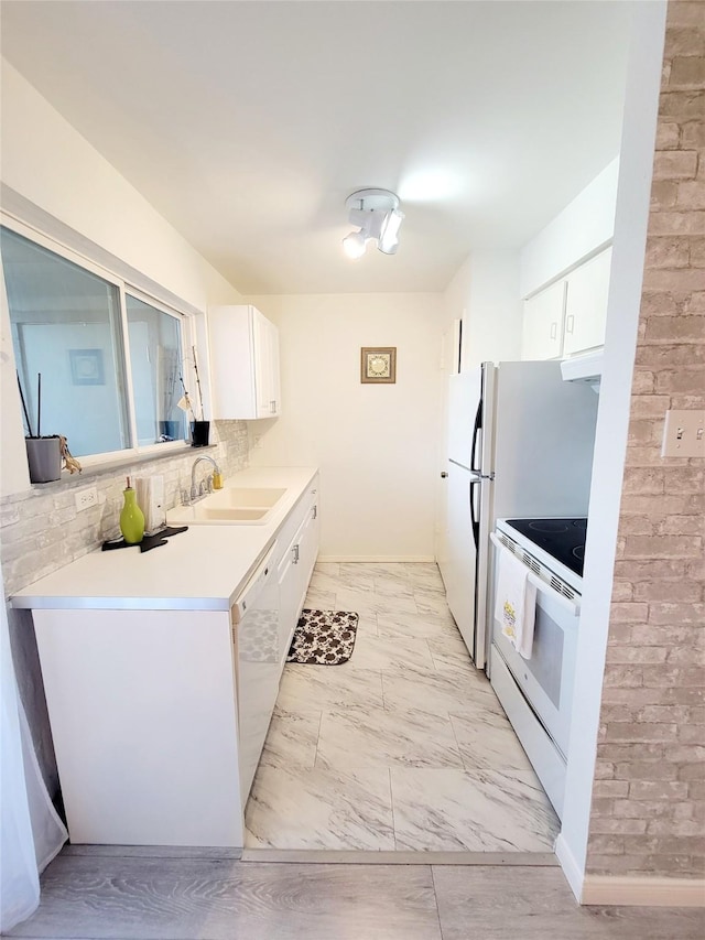 kitchen with sink, backsplash, white cabinets, and white appliances