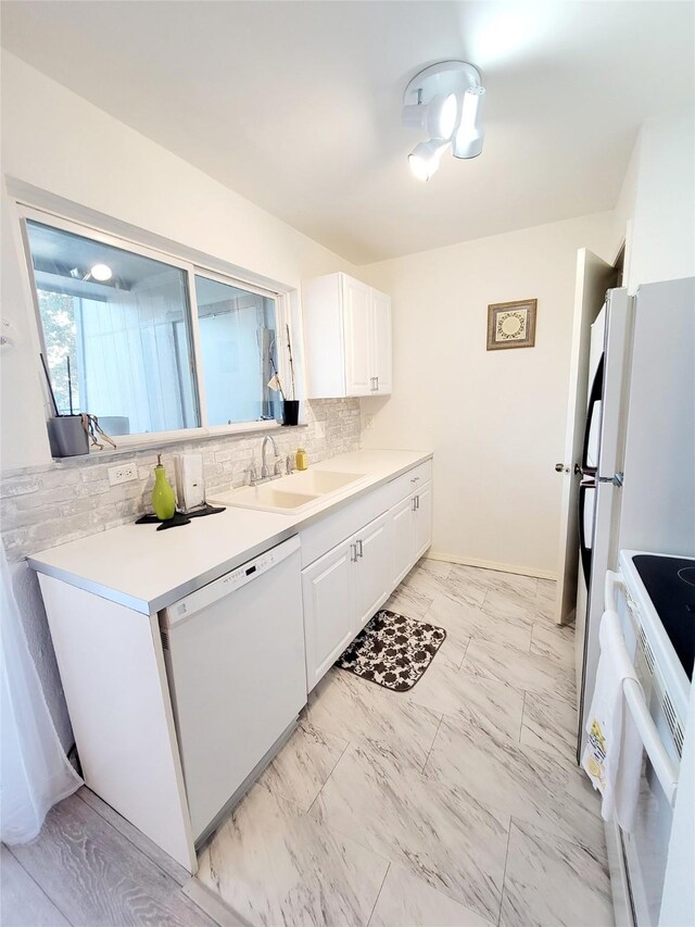 kitchen featuring white cabinetry, sink, decorative backsplash, and white appliances